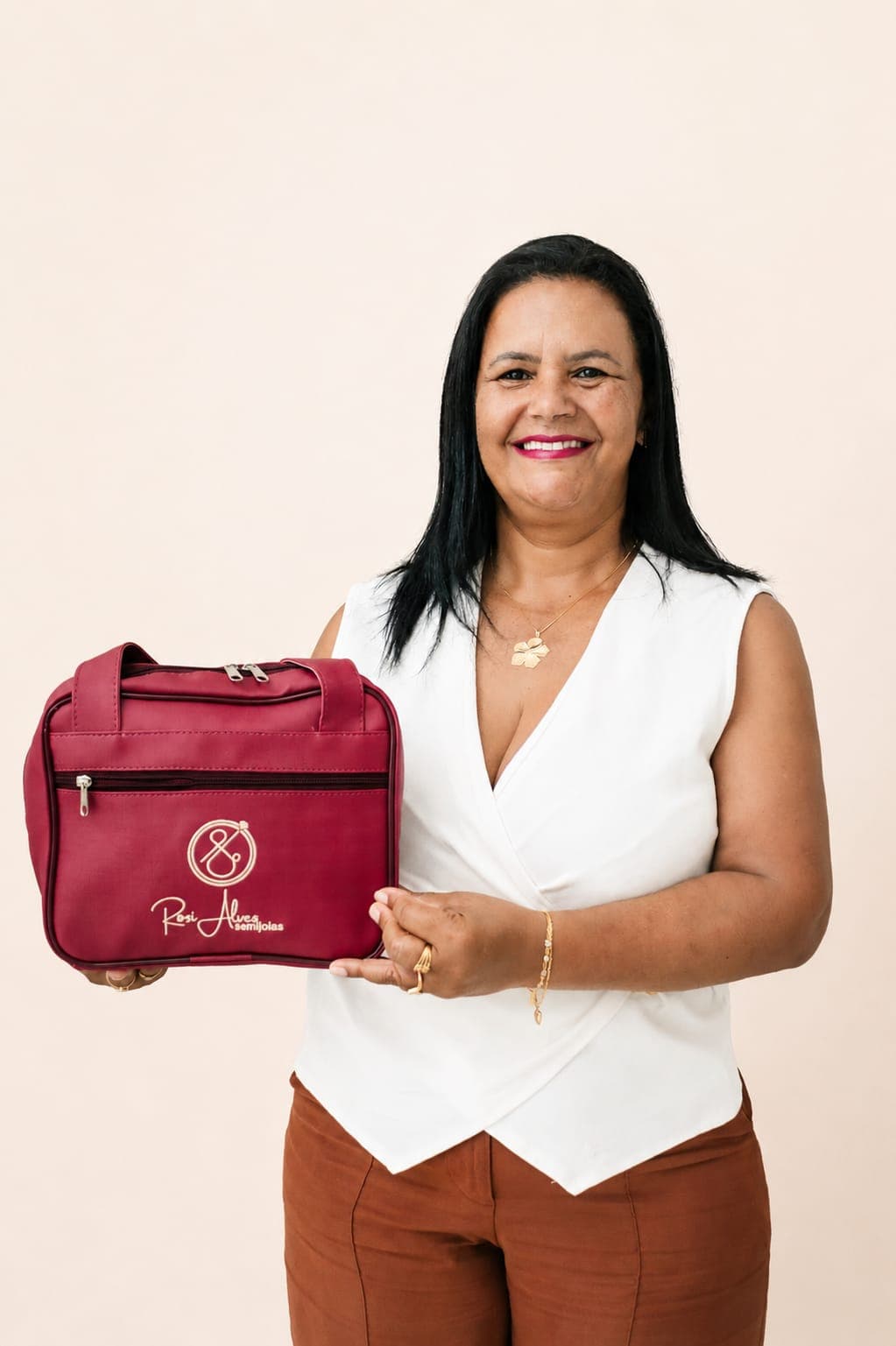 Rosi Alves segurando bolsa mostruário da marca, sorrindo